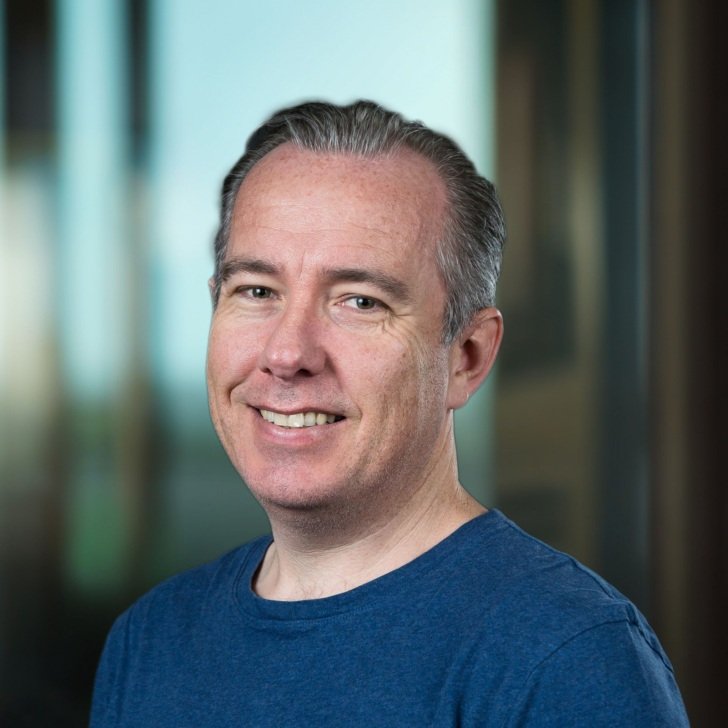 Man with grey hear and wearing a blue t-shirt