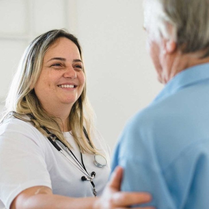 Female health professional smiling at an elderly patient