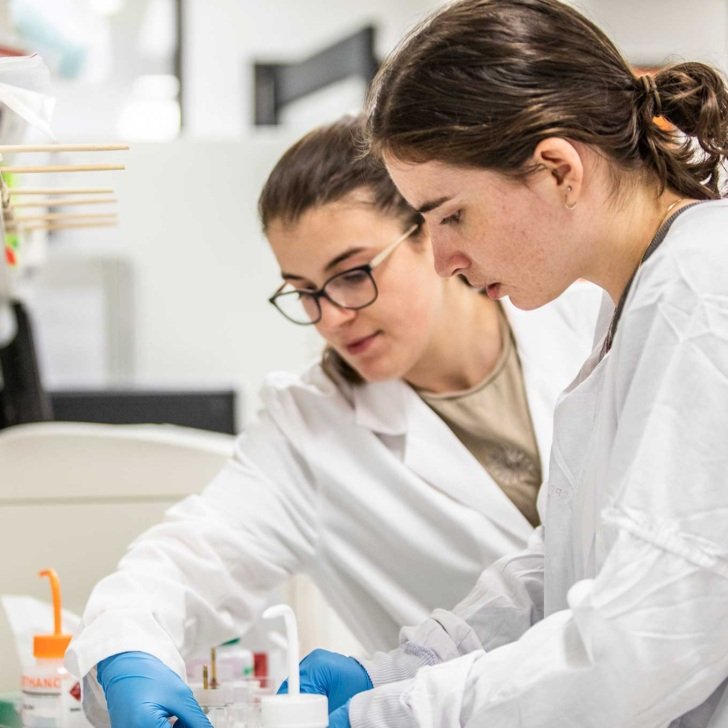 Two female researchers working together in lab