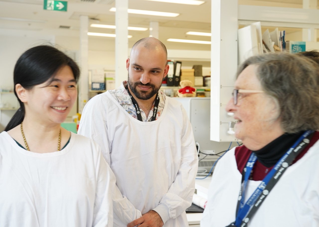 student researchers in the lab with white lab coats