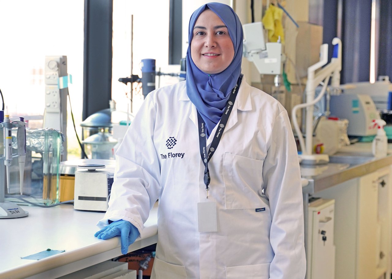 Dr Alaa Abdul-Rhida wears white labcoat with blue headscarf