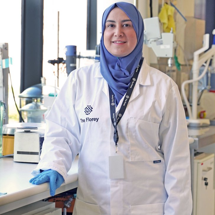Dr Alaa Abdul-Rhida wears white labcoat with blue headscarf