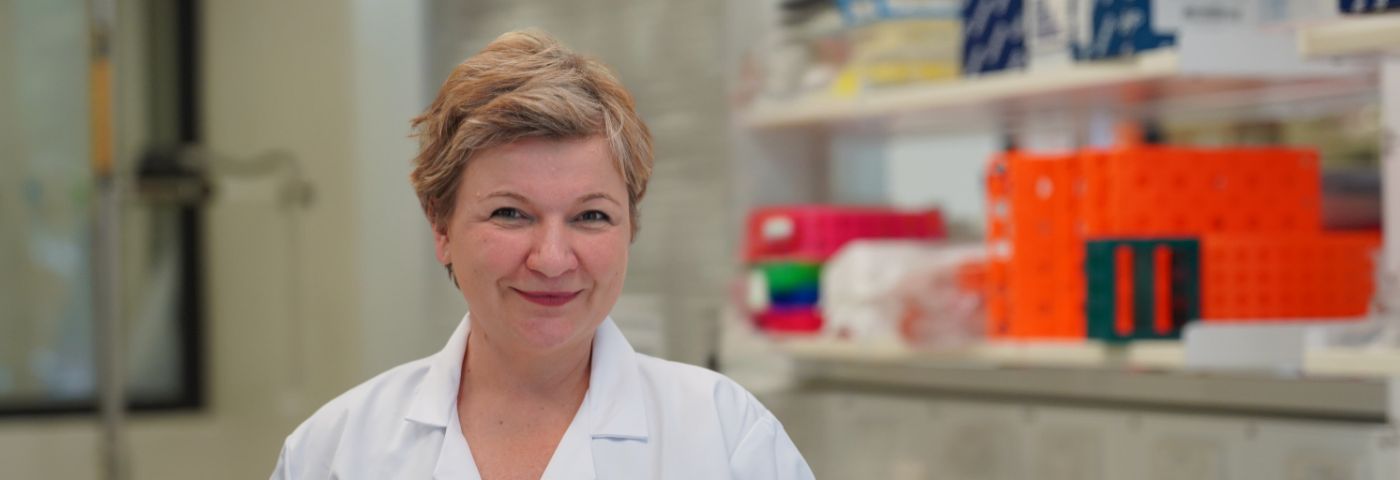 Woman with short brown hair wearing a white lab coat