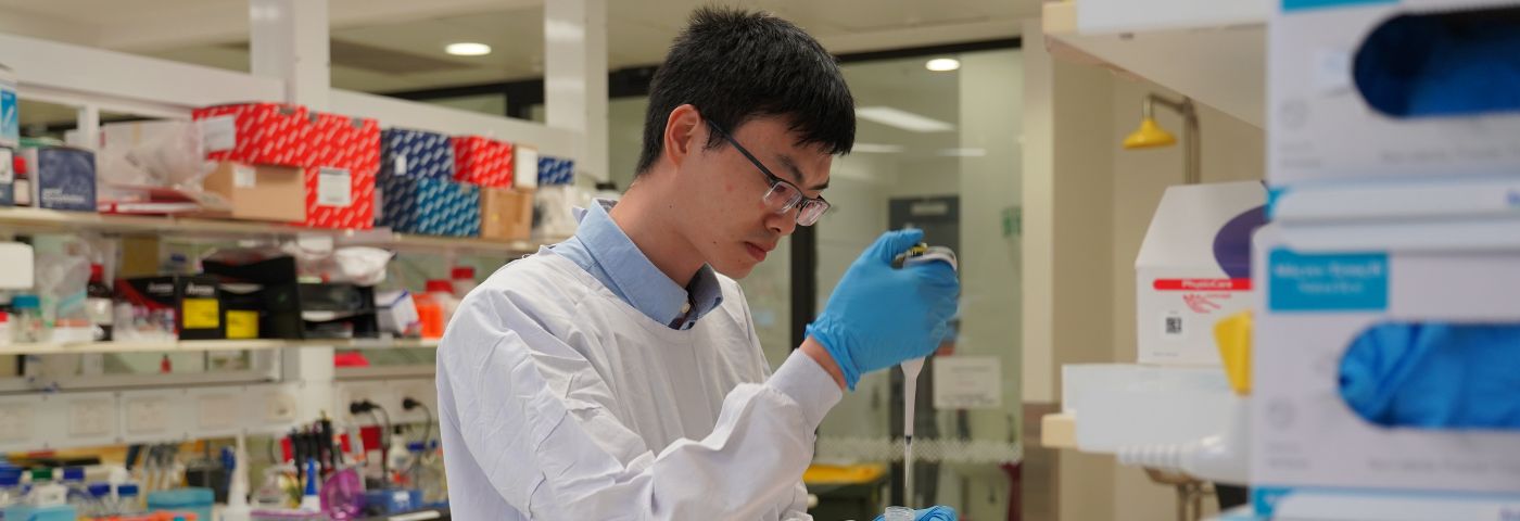 Male researcher using a pipette in a Florey laboratory.