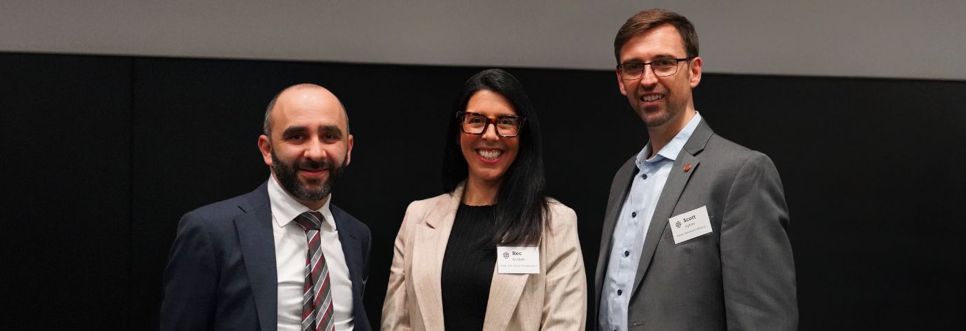 Two male and one female researchers dressed in formal jackets stand side by side