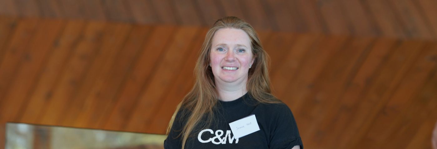 A young woman with long blonde hair wearing a black t-shirt