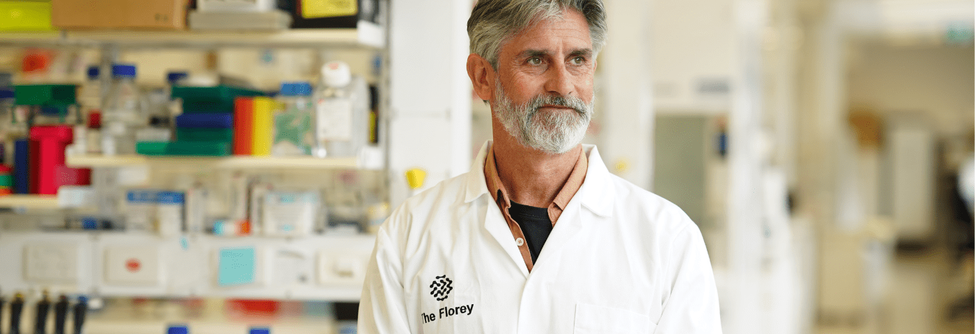 Scientist wearing lab coat stands in research lab