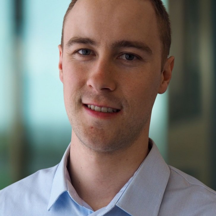 Man wearing pale blue shirt smiles