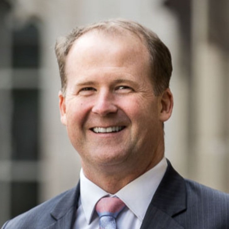 Man in suit and tie smiles