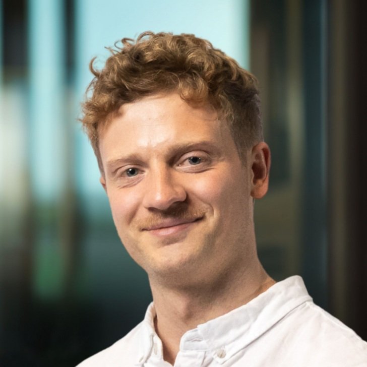 Man wearing white collared shirt smiles