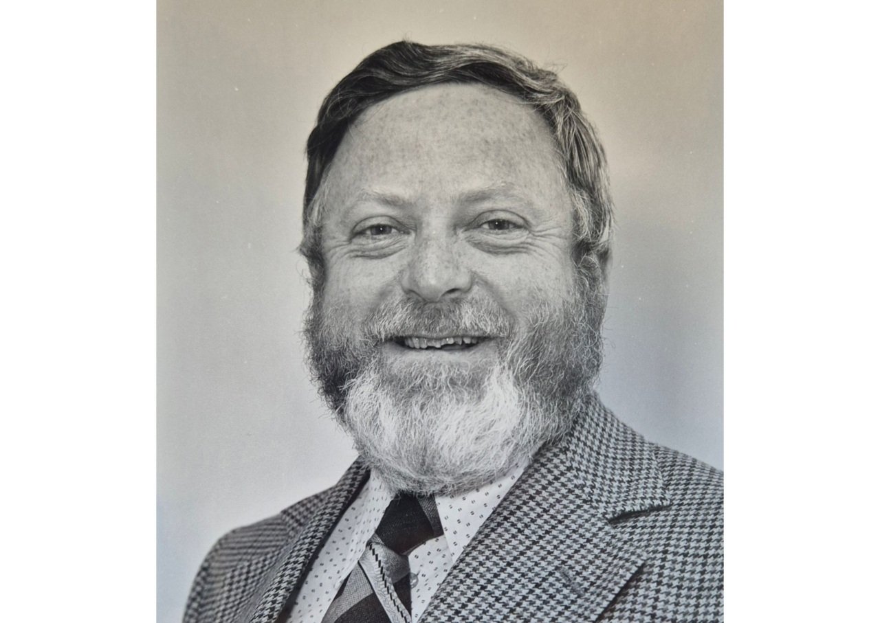 Man wearing suit and tie smiles at camera