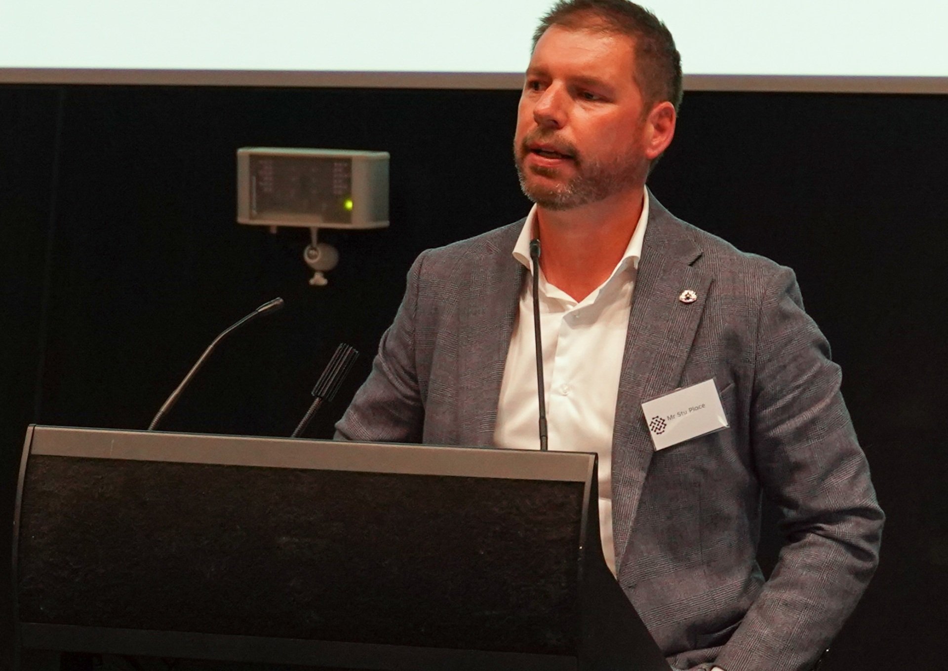 Man stands at podium in auditorium