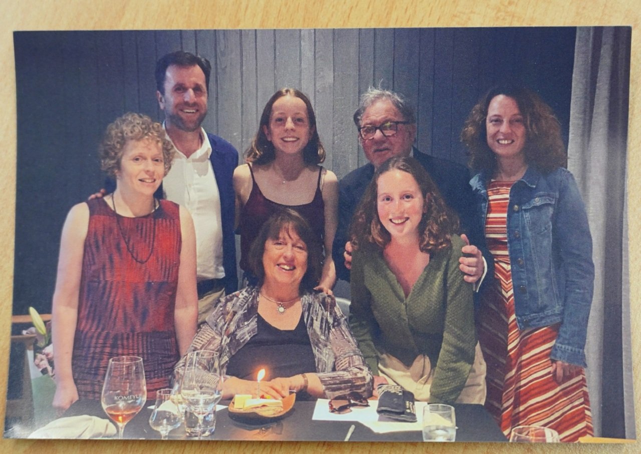 Family members smile for a photo at a dinner table