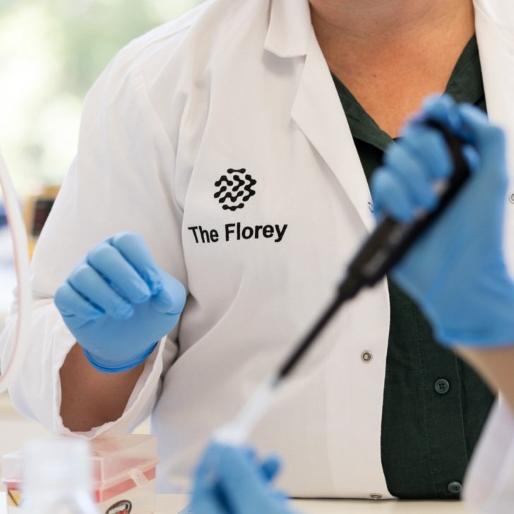 Scientist wearing Florey lab coat does experiment