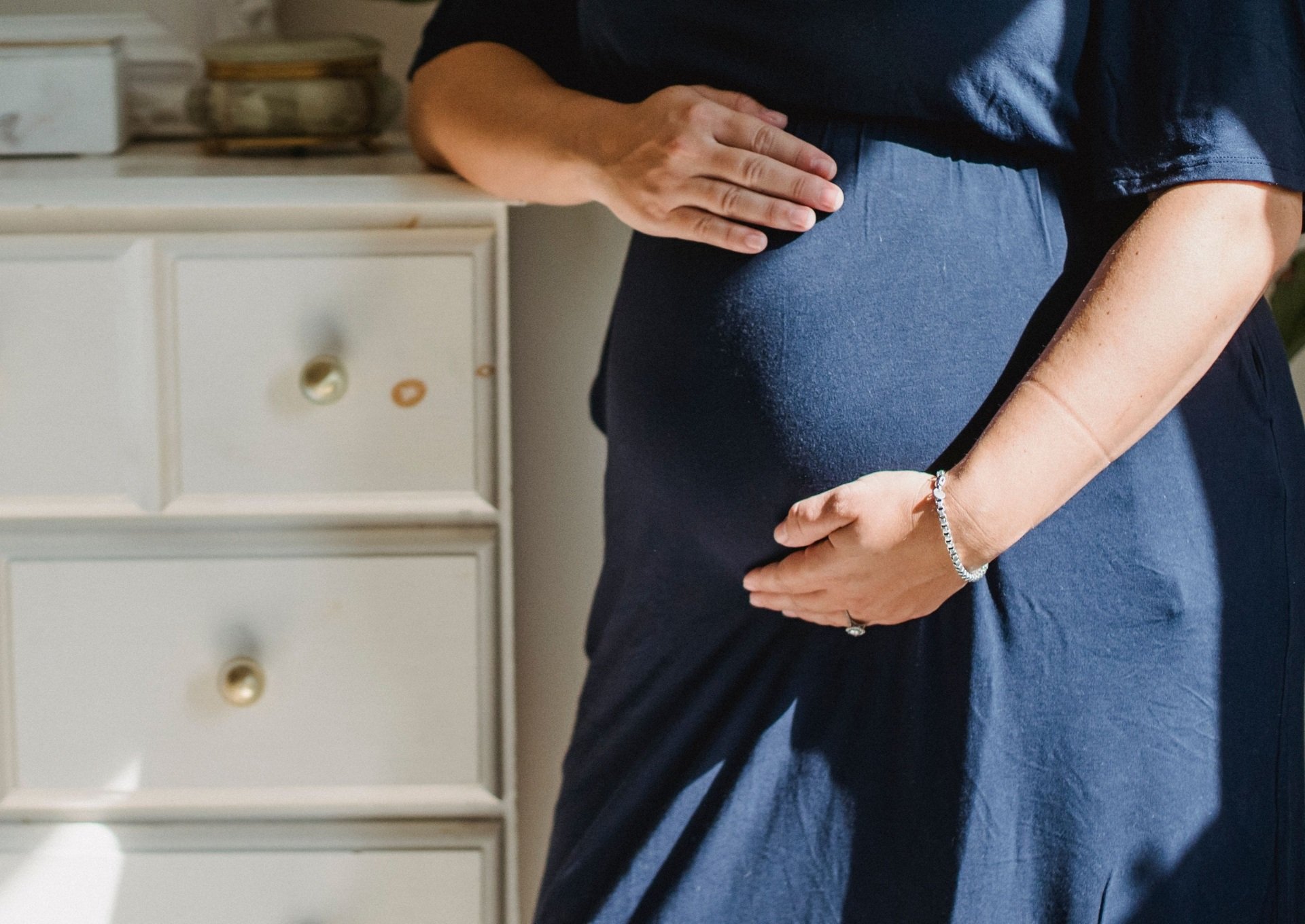 Pregnant woman holds her belly