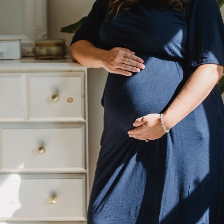 Pregnant woman holds her belly
