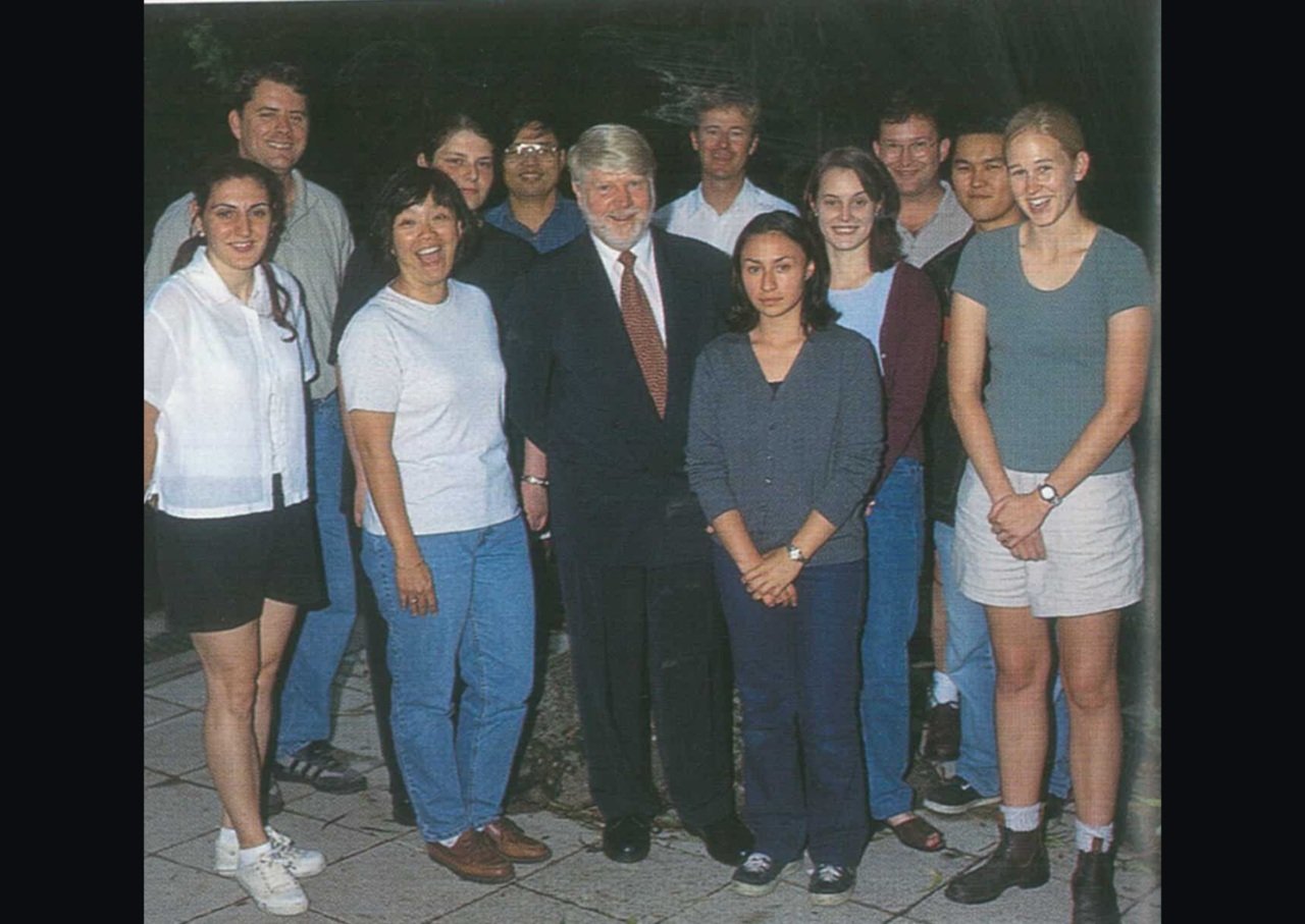 Group of researchers wearing casual clothes stand together smiling