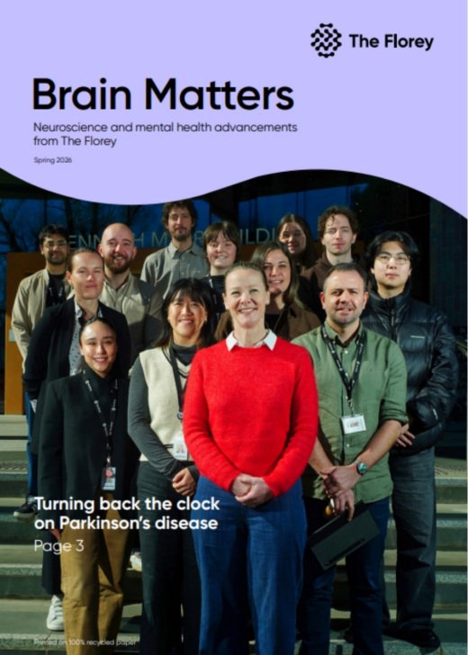 Group of researchers stand smiling at the front of a building.