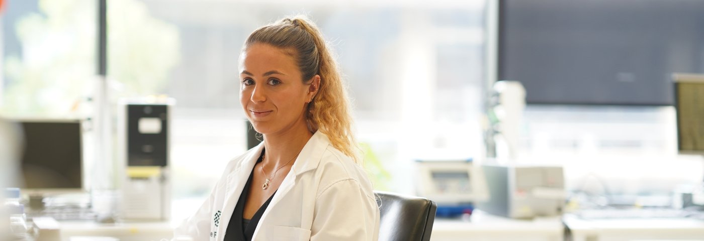 Scientist at lab bench smiles